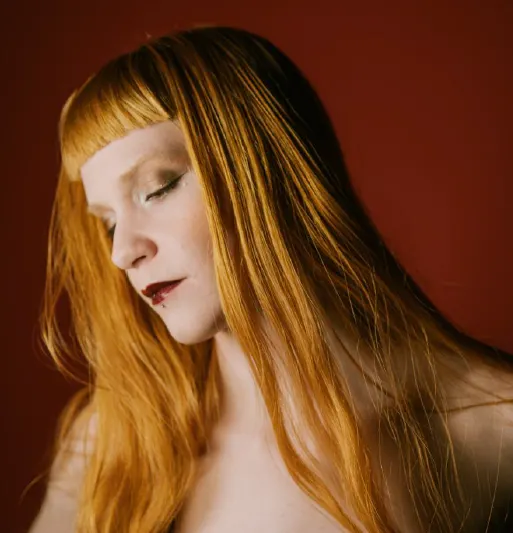 Dana McCool, eyes lowered, long copper hair